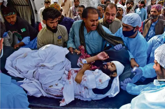  ?? ARSHAD BUTT/ASSOCIATED PRESS ?? Paramedics and volunteers carried an injured victim of a bomb explosion upon arrival at a hospital, in Quetta, Pakistan, Friday.