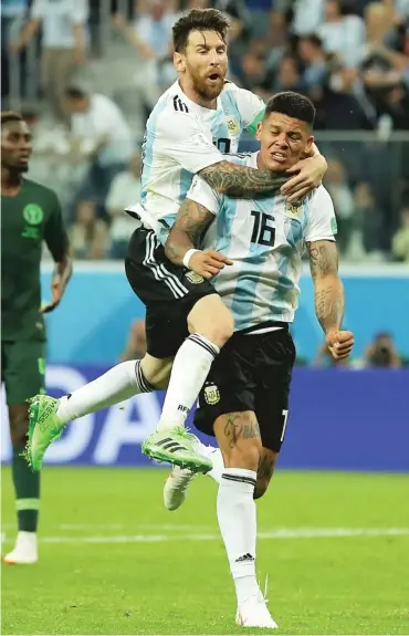  ?? RICHARD HEATHCOTE/ GETTY IMAGES ?? Lionel Messi ( left) celebrates with Marcos Rojo after Rojo’s winner in the 86th minute.