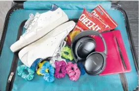  ?? PHOTO BY JAMES ESTRIN/THE NEW YORK TIMES ?? Items Sara Blakely brings with her to mitigate a fear of flying: sneakers, Cheez-Its, an iPod with a good-luck song, Bose headphones and scrunchies.