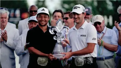  ?? GERALD HERBERT/AP ?? Xander Schauffele, left, and teammate Patrick Cantlay hold up the trophy Sunday after winning the PGA Zurich Classic golf tournament at TPC Louisiana in Avondale, La.