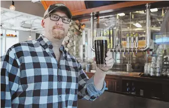  ?? STAFF PHOTO BY NANCY LANE ?? HERE’S TO HEROES: Dave Pappas, who created the Black Ale Project to help veterans, raises a glass of True West Brewery ale.