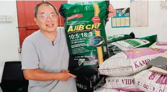  ?? ?? Yong holds up a bag of AJIB CRF fertiliser, now available at Abundant General Trading Co.