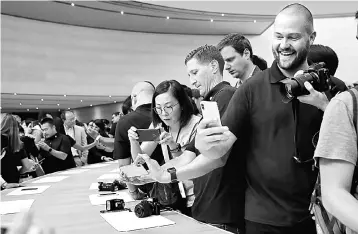  ??  ?? An attendee looks at a new iPhone X during an Apple special event at the Steve Jobs Theatre on the Apple Park campus. Inari is anticipate­d to be supported by Apple’s brand new iPhone X, 8 and 8 plus models. — AFP photo
