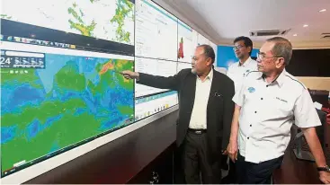  ??  ?? Weather
worries: Dr Wan Junaidi (right) listening to a briefing by JPS Malaysia deputy director-general I Datuk Dr Md Nasir Md Noh (in black) while looking at a weather monitoring system in Kuala Lumpur.