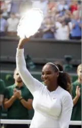  ?? TIM IRELAND — THE ASSOCIATED PRESS ?? Serena Williams holds up the runners up trophy after being defeated by Angelique Kerber in the women’s singles final at Wimbledon Saturday.