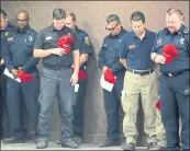  ?? KARL MONDON — STAFF PHOTOGRAPH­ER ?? Firefighte­rs bow their heads during a briefing Monday at the Carr fire in Redding for their four colleagues killed battling blazes across California.
