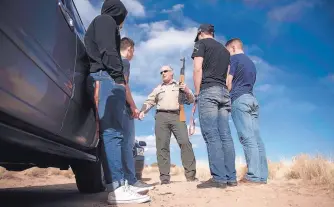  ?? ROBERTO E. ROSALES /JOURNAL ?? Illegal shooting is one of the most common reasons Sandoval County sheriff’s deputies are called to the Rio Rancho Estates Area west of the city. Here, Lt. Keith Elder talks to four young men, ages 18 to 20, who brought an AK-47 with them from...
