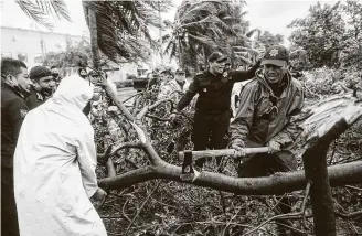  ?? Victor Ruiz Garcia / Associated Press ?? Firefighte­rs remove a tree toppled by Hurricane Delta in Cancun, Mexico, earlyWedne­sday. Delta made landfallWe­dnesday just south of the Mexican resort as a Category 2 storm.