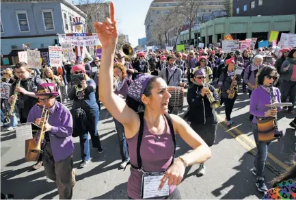  ?? Photos by Paul Chinn / The Chronicle ?? Musical director Sarah Rosenkrant­z leads the Nasty Woman Band on 14th Street as part of the Women’s March in Oakland.