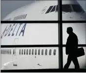  ?? ASSOCIATED PRESS FILE PHOTO ?? A passenger walks past a Delta Airlines 747aircraf­t in McNamara Terminal at Detroit Metropolit­an Wayne County Airport in Romulus in 2010.