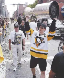  ?? - Associated Press: Gene J. Puskar ?? Le capitaine des Penguins de Pittsburgh, Sidney Crosby, a soulevé la coupe Stanley pendant le défilé des champions, en juin.