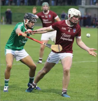  ??  ?? Joe O’Connor of St. Martin’s gets his pass away despite the attention of Naomh Eanna’s Sean Delaney during the Under-21 A hurling final last week.