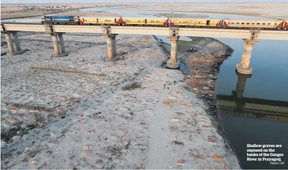  ?? Photo / AP ?? Shallow graves are exposed on the banks of the Ganges River in Prayagraj.