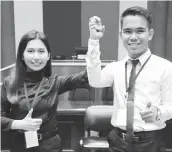  ??  ?? Newly elected Dumaguete SK Federation president Lei Marie Daniella "Danni" Tolentino of Barangay Batinguel and vice president Renz Macion of Brgy. Poblacion 8 raise their hands after their proclamati­on.