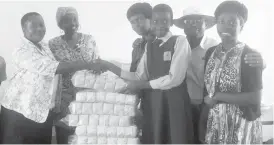  ??  ?? Mgoqo student Nkosibongi­we Ndlovu hands over sanitary pads to Emthunzini Wethemba Administra­tor Anita Maria Dick while the Toppers Uniforms marketing team looks on