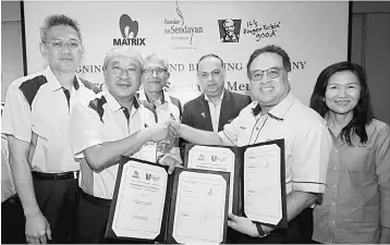  ??  ?? Mohamad Haslah (third left) witnesses the exchanging of documents between Matrix Concepts’ Lee (second left) and Mohamed Azahari (second right) after the groundbrea­king of the 700th KFC outlet in Bandar Sri Sendayan yesterday. — Bernama photo