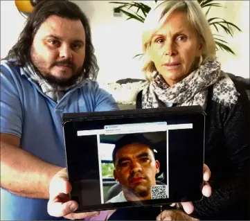  ??  ?? Fred Vacherié et Martine Jaurgoyhen exhibent la photo de Ricardo Dos Santos, soupçonné du meurtre de leur frère et fils, toujours recherché dans l’État de São Paulo au Brésil. (Photo A. C.)