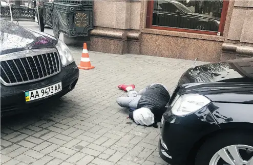  ?? ALISA BEREZUTSSK­AYA / THE ASSOCIATED PRESS ?? An assassin, who shot and killed Denis Voronenkov, lies wounded in Kyiv. Ukrainian officials said Voronenkov was shot Thursday by 28-year- old Pavel Parshov, who they claim had been trained by Russian security services.
