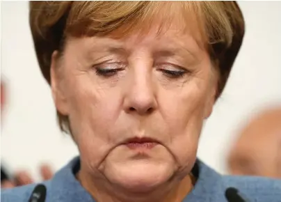  ??  ?? Sombre: Angela Merkel pictured addressing party supporters last night after her election win