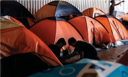  ?? Photograph: Guillermo Arias/AFP via Getty Images ?? Asylum seekers play at a migrant shelter in Tijuana, Baja California state, Mexico, on 18 October.