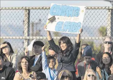  ?? Brian van der Brug
Los Angeles Times ?? FINANCIAL EXPERTS estimate that senior-year activities could cost from $5,000 to $10,000. Above, Shalimar Green holds up a sign at the North Hollywood High graduation of her sister Clarisa Ortega.