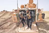  ?? POOL PHOTO VIA AP ?? Iraqi soldiers leave a Turkish army armored vehicle Tuesday during military exercises in Silopi, Turkey, near the Iraqi border. Iraqi, Iranian and Turkish leaders are holding firm to their pledge to block Kurdish separation from Iraq.