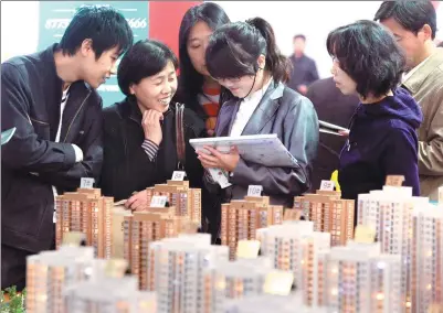  ?? LIU DONGYUE / XINHUA ?? Potential homebuyers talk with a sales representa­tive at a real estate fair in Tianjin, one of the cities affected by the latest round of tightened home loan policy.