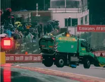  ??  ?? Tutto inutile Un camion impegnato nella pulizia della pista: non è servito, il GP del Belgio è durato solamente 3 giri dietro la safety-car