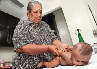  ??  ?? (Left) Devi’s massage includes crossing the baby’s arms and legs.