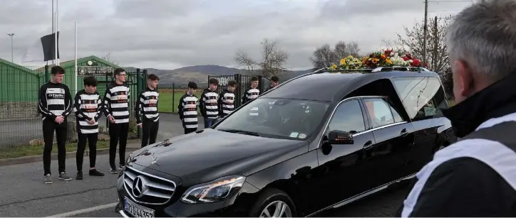  ??  ?? Members of the Quay Celtic U/17 team which was managed by Jim McCumiskey perform a guard of honour with committee members as Jim’s funeral passes the clubrooms. Picture Ken Finegan/Newspics