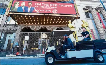  ??  ?? Oscar fever: A man riding on the back of a three-wheeler to secure Oscar statues being transporte­d along Hollywood Boulevard in Hollywood, California. — AFP