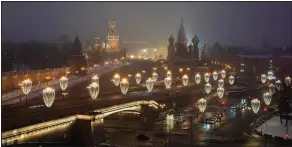  ?? (AP/Alexander Zemlianich­enko) ?? The Kremlin Wall, the Spasskaya Tower, Red Square, the GUM department store, the St. Basil’s Cathedral and the Bolshoy Moskvorets­ky Bridge are decorated for Christmas and the New Year festivitie­s Dec. 12 in Moscow.