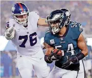 ?? [AP PHOTO] ?? Philadelph­ia Eagles linebacker Kamu Grugier-Hill (54) runs back an intercepti­on as New York Giants offensive tackle Nate Solder (76) chases him during the first half of Thursday night’s game in East Rutherford, N.J. The Eagles won 34-13.