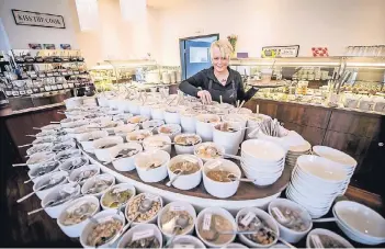  ?? RP-FOTO: ANDREAS ENDERMANN ?? Aus mehr als 100 Töpfen können die Besucher des Hotels Auszeit (hier: Maike Petersen) Zutaten für ihr Müsli schöpfen. Hinten links im Bild: das Regal mit den Marmeladen und Schokoaufs­trichen.