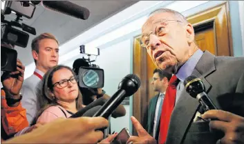  ?? AP PHOTO ?? Sen. Chuck Grassley, R-Iowa, right, answers questions from reporters about allegation­s of sexual misconduct against Supreme Court nominee Brett Kavanaugh Wednesday as he arrives for a Senate Finance Committee hearing on Capitol Hill in Washington.