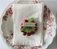  ??  ?? These cheerful cranberry napkin rings are easy to make, using fresh cranberrie­s, greenery, wire, paper and scissors.