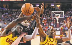  ?? Mark J. Terrill / Associated Press ?? USC forward Chimezie Metu (left) and guard Shaqquan Aaron battle for the ball against Utah forward Chris Seeley in the Trojans’ victory in Los Angeles.