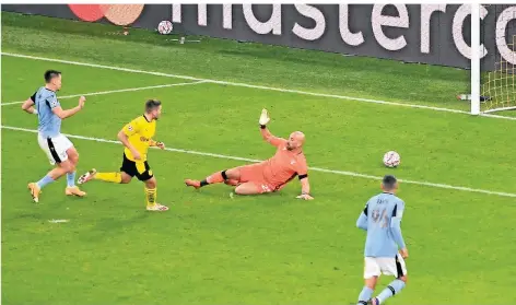  ?? FOTO: BERND THISSEN/DPA ?? Dortmunds Raphael Guerreiro erzielt das Tor zum 1:0 gegen Lazios Torwart Pepe Reina.