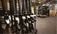  ?? Associated Press ?? A rack of AR-15-style rifles stand to be individual­ly packaged as workers move a pallet of rifles for shipment at the Stag Arms Company in New Britain in 2013.