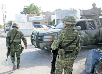  ??  ?? Soldados prestan guardia afuera de la sede de la Fiscalía; además, elementos de la Policía Federal y de la Gendarmerí­a llegan hoy al balneario de Cancún, luego del ataque armado a instalacio­nes oficiales.