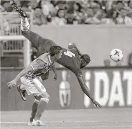  ?? Brett Coomer / Houston Chronicle ?? Ghana’s Jonathan Mensah, top, takes a tumble after jumping past Mexico’s Angel Sepulveda to head the ball during the first half Wednesday at NRG Stadium.