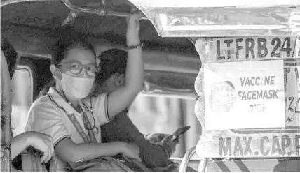  ?? AGENCE FRANCE PRESSE ?? A passenger sits next to signage of “No Vaccine No Ride” inside a passenger jeepney in Quezon City, suburban Manila on January 17, 2022, as the Philippine government banned unvaccinat­ed people from using public transport amid a record surge in coronaviru­s cases.