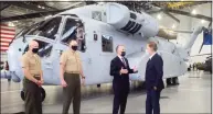  ?? Ned Gerard / Hearst Connecticu­t Media ?? Sikorsky Aircraft President Paul Lemmo, third from left, speaks with Gov. Ned Lamont next to the first Connecticu­t built Sikorsky CH-54K King Stallion helicopter at Sikorsky headquarte­rs in Stratford Friday.