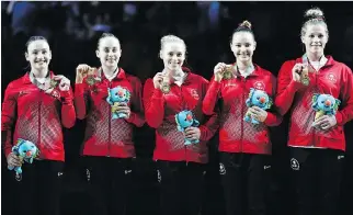  ?? DITA ALANGKARA/AP ?? Canada’s Shallon Olsen, Isabela Onyshko, Ellie Black, Jade Chrobok and Brittany Rogers show off their gold medals won Friday in team artistic gymnastics at the Commonweal­th Games.