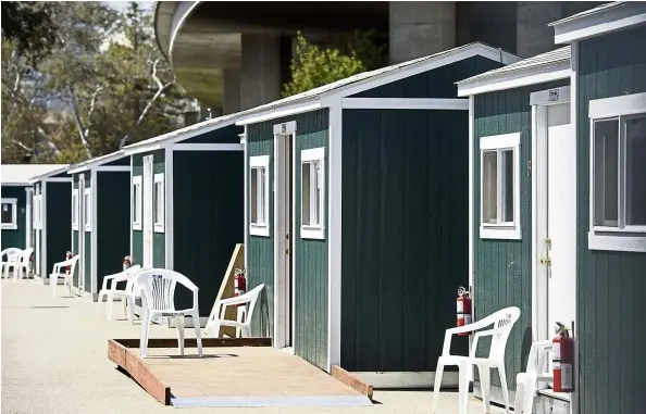  ?? — Bloomberg ?? The city of Oakland in the United States has opened a Tuff Shed community shelter site, part of an ongoing pilot project, consisting of 20 structures that will temporaril­y house 40 homeless residents for up to six months and provide them with basic services and on-site case managers.