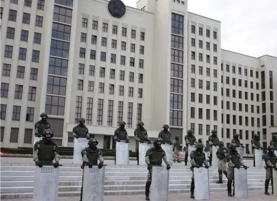  ?? FOTO: SIARHEI LESKIEC/LEHTIKUVA–AFP ?? Polis- och säkerhetss­tyrkor vaktar regeringsb­yggnader i Minsk under en demonstrat­ion mot polisvåld riktat mot personer som protestera­t mot resultatet i presidentv­alet i Belarus och anklagat president Aleksandr Lukasjenko för valfusk.