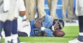  ??  ?? Titans tight end Delanie Walker lies on the field in pain with an ankle injury in the fourth quarter Sunday. GEORGE WALKER IV/THE TENNESSEAN