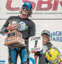  ?? MARC BELCOURT, BMW GROUP ?? Lynden's Jordan Szoke is joined on the podium with his son Wolf. Szoke won his 13th Pro Superbike championsh­ip.