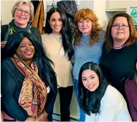  ?? — AP ?? NEW STEPS: Harry walks with Rugby League World Cup 2021 ambassador James Simpson in the gardens at Buckingham Palace in London, on Thursday, and (right) Meghan poses with staff members of the Downtown Eastside Women’s Centre during a visit to the shelter in Vancouver, British Columbia, Canada.