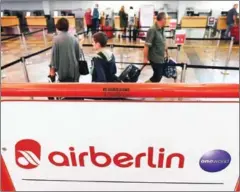  ?? HELMUT FOHRINGER/AFP ?? Passengers check in at the Air Berlin counter at the airport in Vienna yesterday.